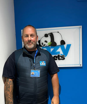 staff in work uniform standing infront of brand logo