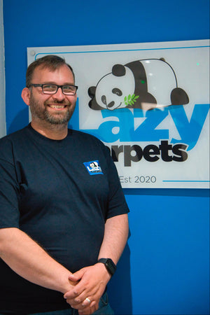 staff in work uniform standing infront of brand logo