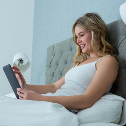 Women on her tablet sat up in bed