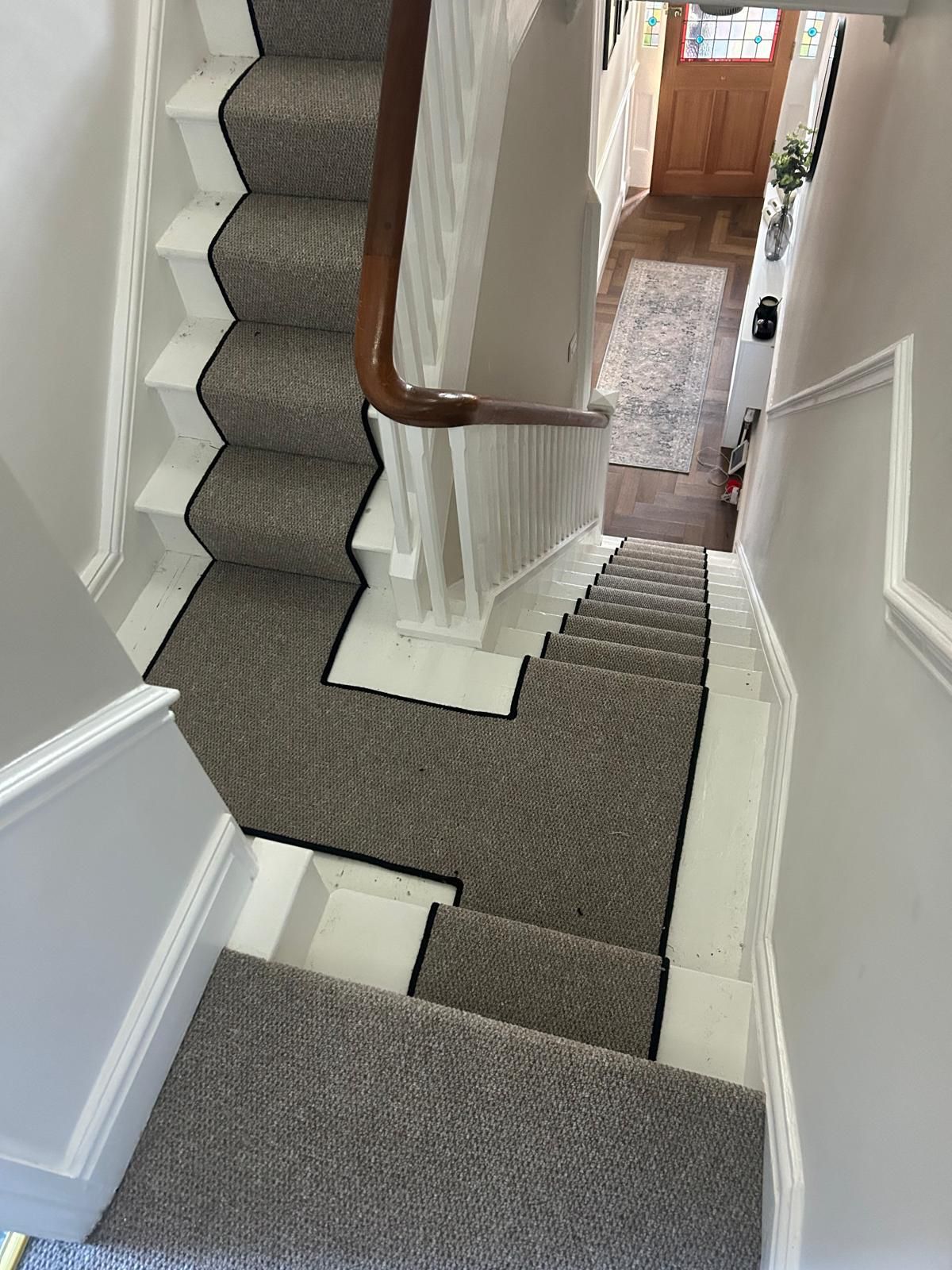  carpeted staircase with wooden handrail in a home setting