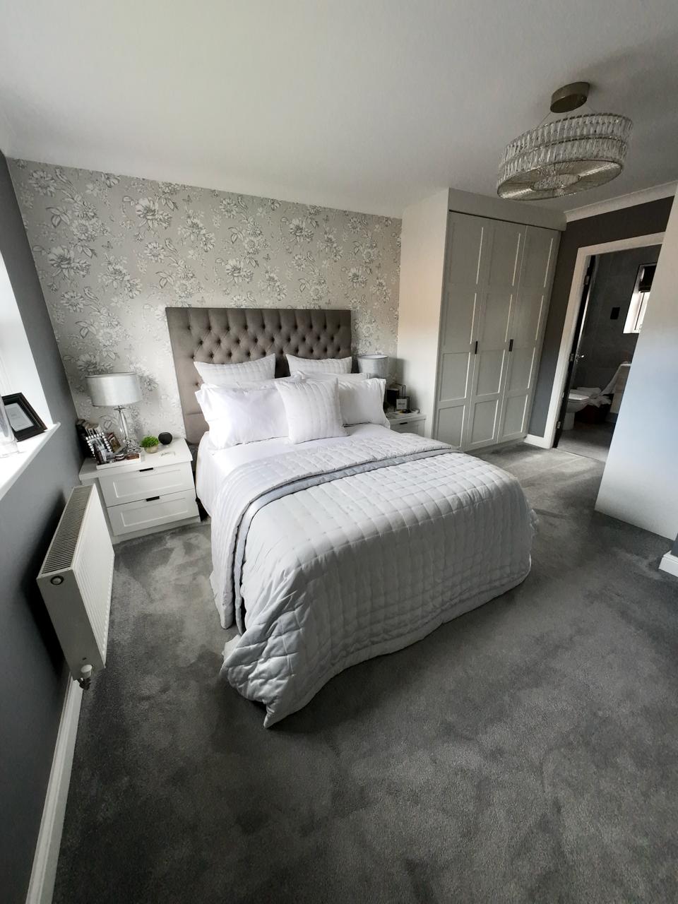Modern bedroom with a bed, nightstands, and decorative wall.